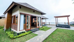 A modern house with a patio, a covered seating area, and a view of the sea. - Shankara Munduk Bali (Munduk)