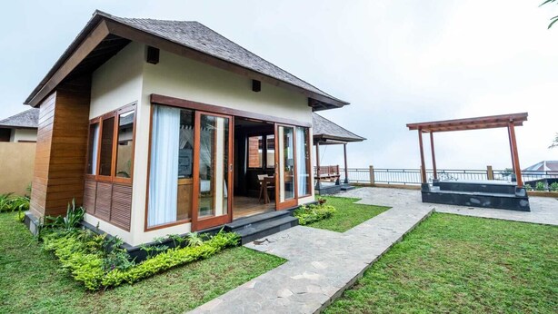 Een modern huis met terras, een overdekte zithoek en uitzicht op zee.