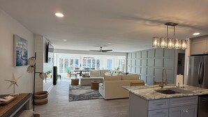 A modern kitchen with a central island, built-in appliances, and a view to the living area.