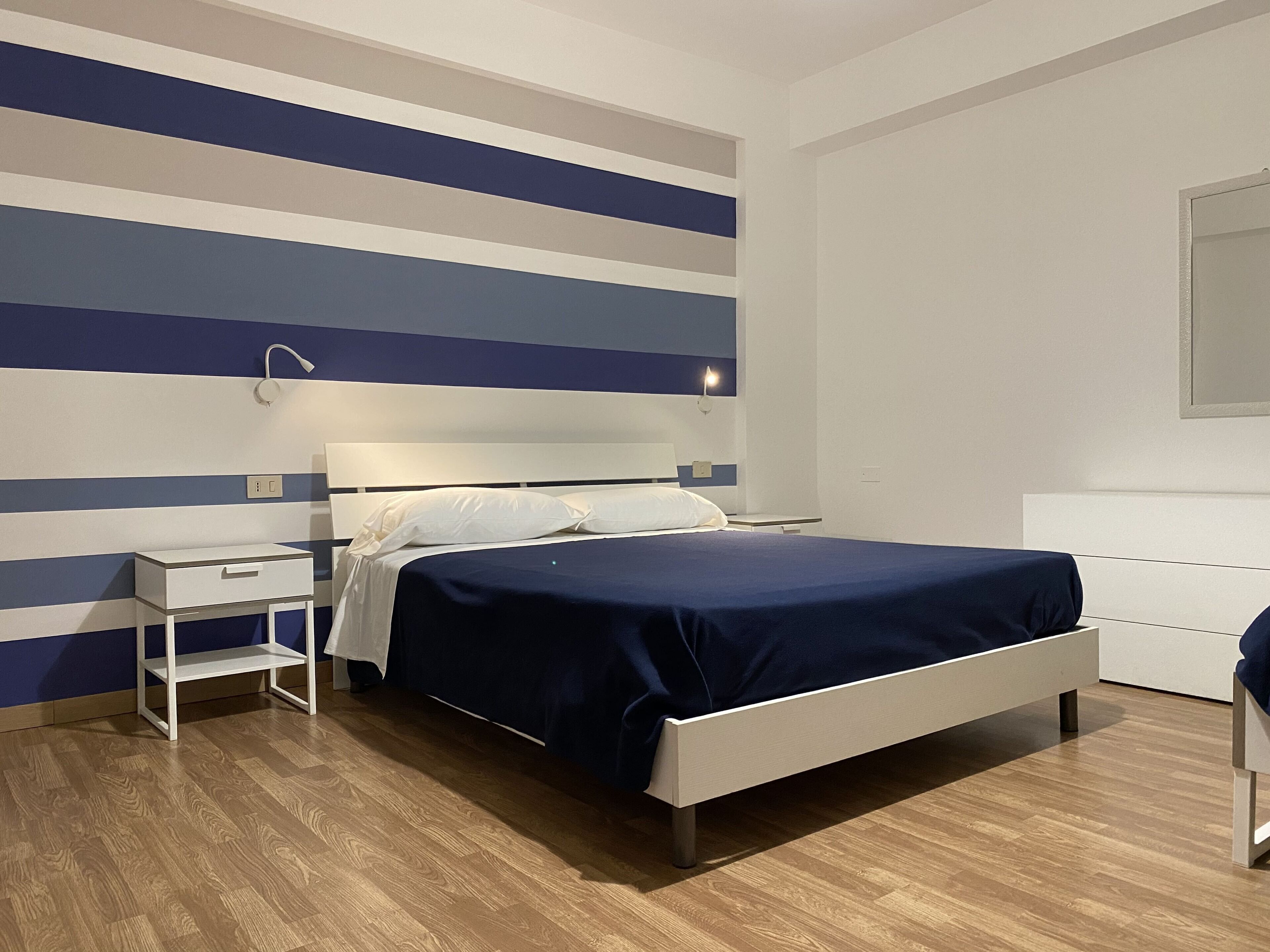 A modern bedroom with a bed, bedside table, and a nightstand.