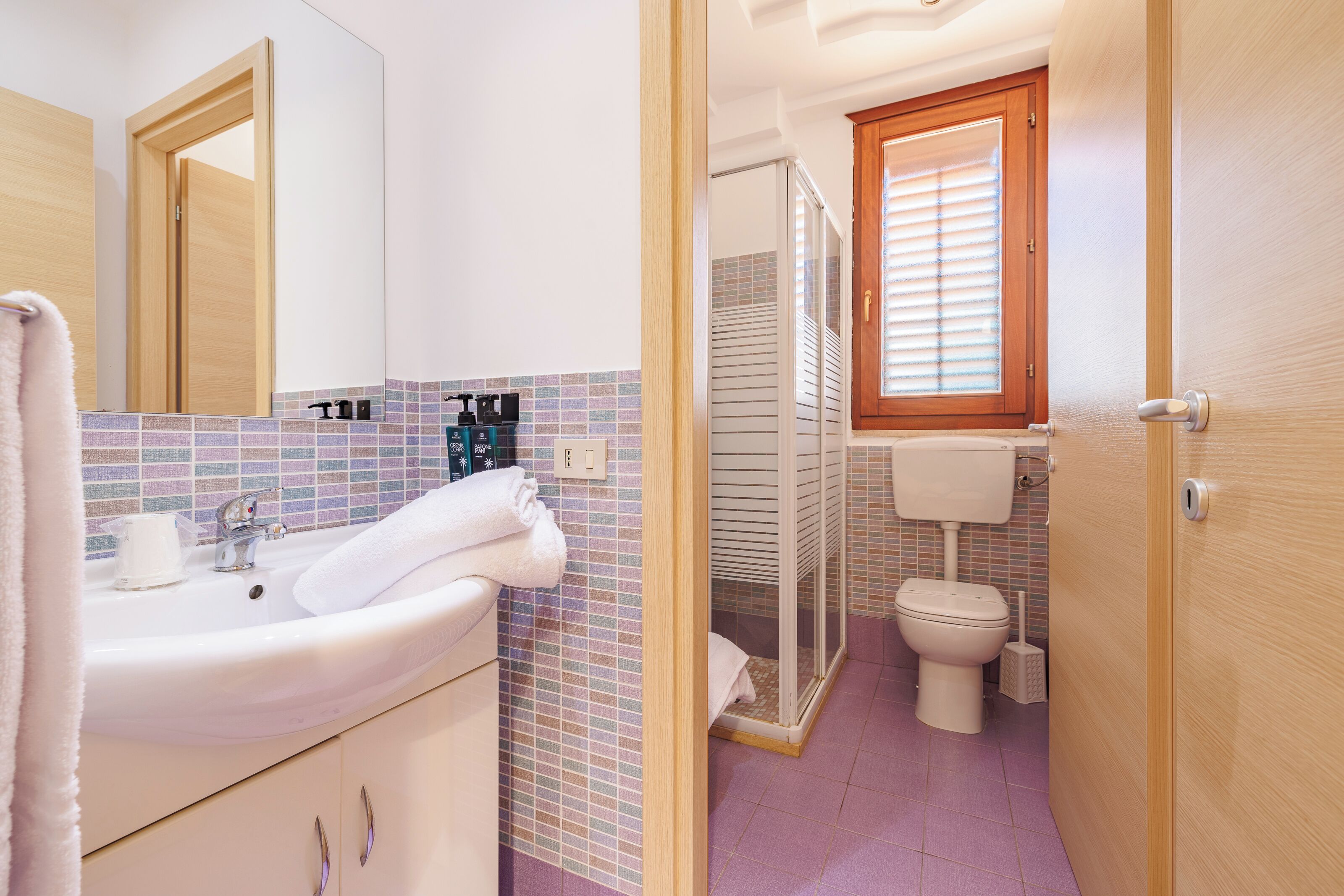 Un baño con lavamanos, espejo e inodoro.