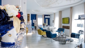 A modern living room with a blue and yellow color scheme, featuring a sofa, chairs, and a coffee table. - Marina di Petrolo Apartments (Castellammare del Golfo)