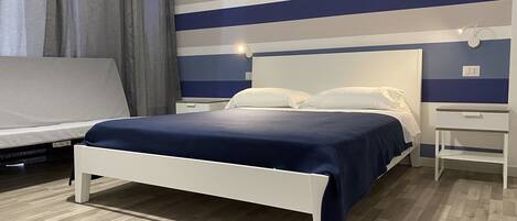 Ein modernes Schlafzimmer mit einem Bett, Nachttischen und einem Sofa.
