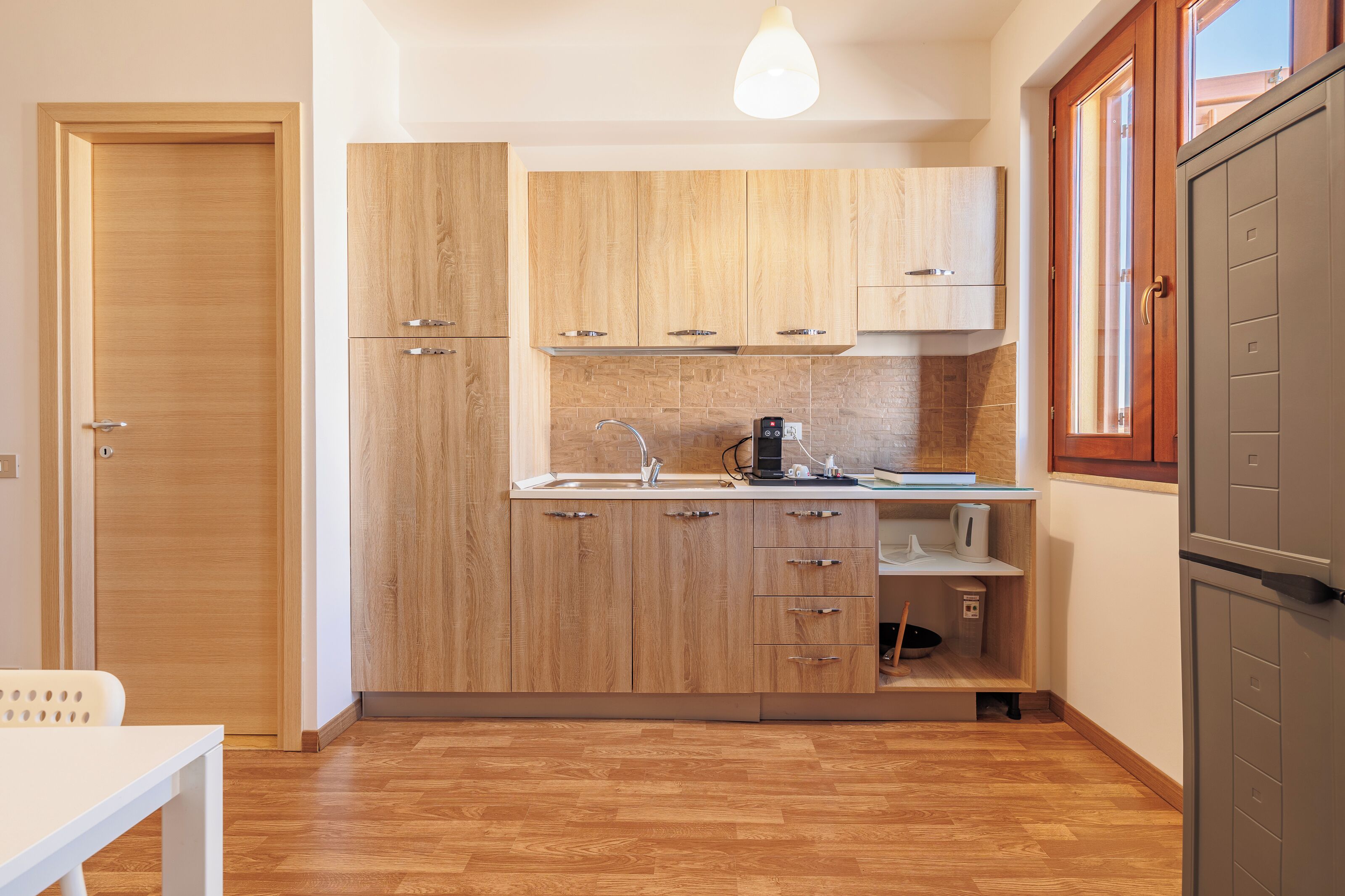 A modern kitchen with wooden cabinets, a sink, and a built-in oven.