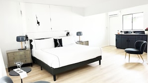 A modern bedroom with a bed, bedside tables, a desk, and a chair. - Jazz Hotel Palm Springs (Palm Springs)