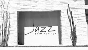 A building facade with a large window displaying the text "JAZZ Palm Springs". - Jazz Hotel Palm Springs (Palm Springs)