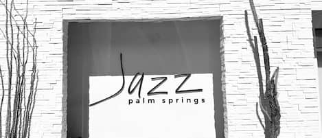 La façade d’un immeuble est ornée d’une grande fenêtre sur laquelle on peut lire l’inscription « JAZZ Palm Springs ».
