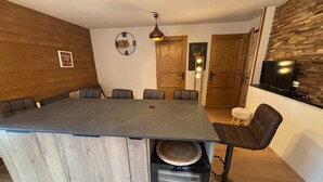 Una cocina moderna con una isla grande, paredes de madera y una estufa integrada.