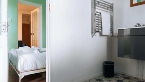 A bedroom with a bed, a radiator, a trash bin, and a wardrobe. - Peaceful 1BD Flat With Private Garden, Brighton! (Brighton)