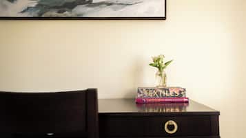 A dark wooden desk with a vase of flowers and a stack of books.