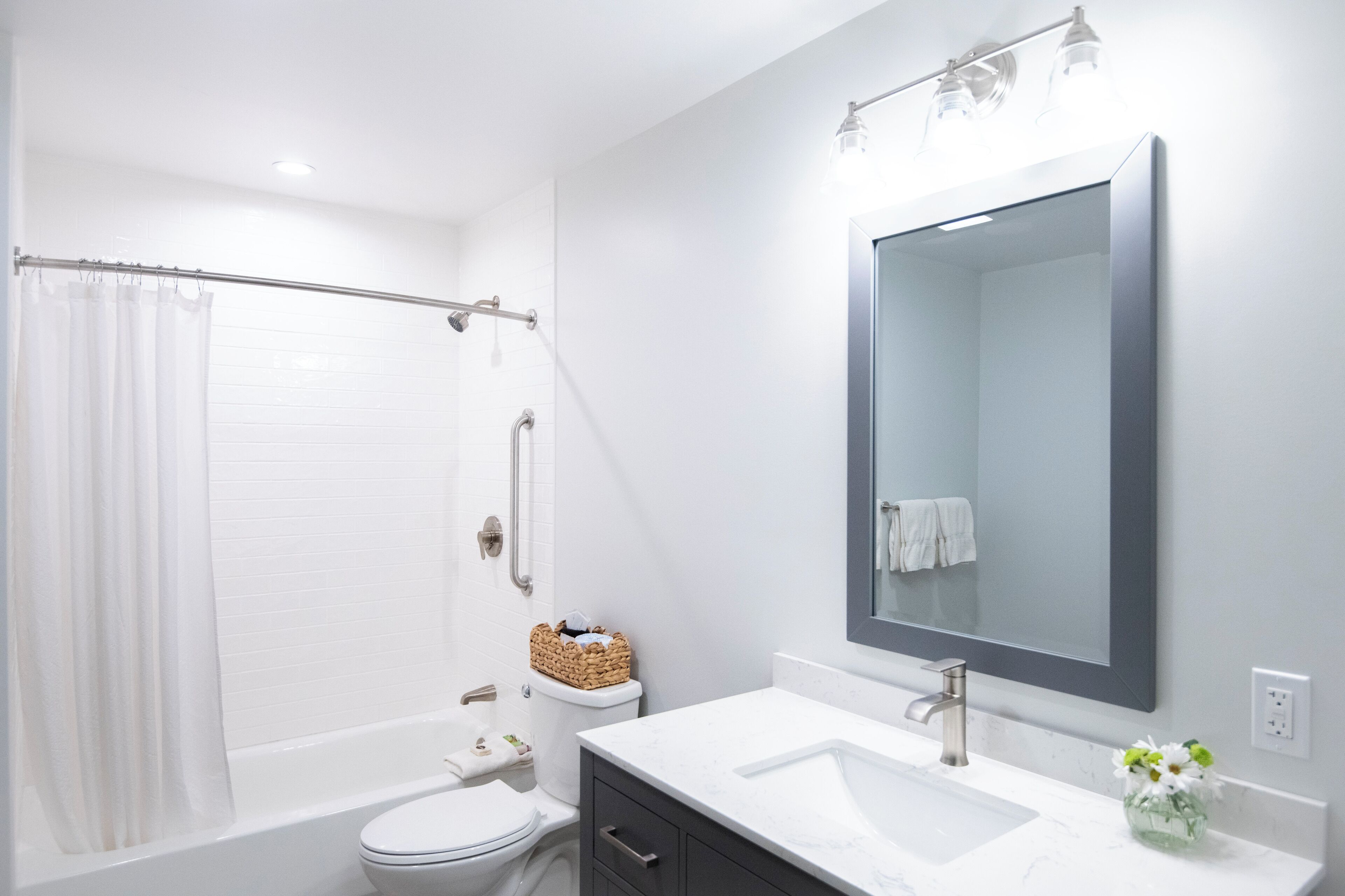 A modern bathroom with a bathtub, toilet, and sink.