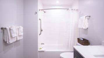 Un baño moderno con bañera, inodoro y cortina de ducha.