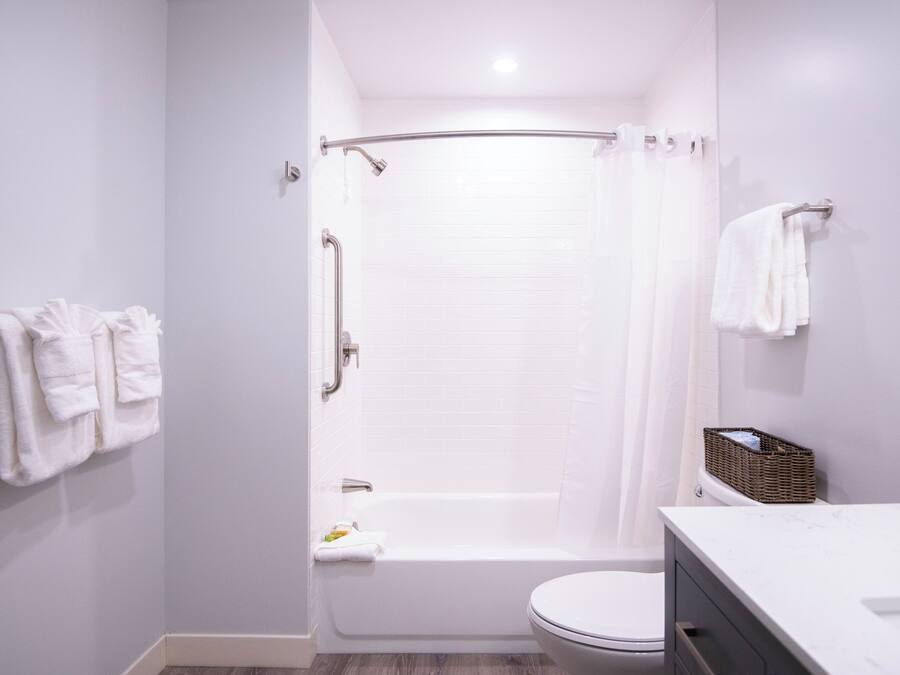 Un baño moderno con bañera, inodoro y cortina de ducha.