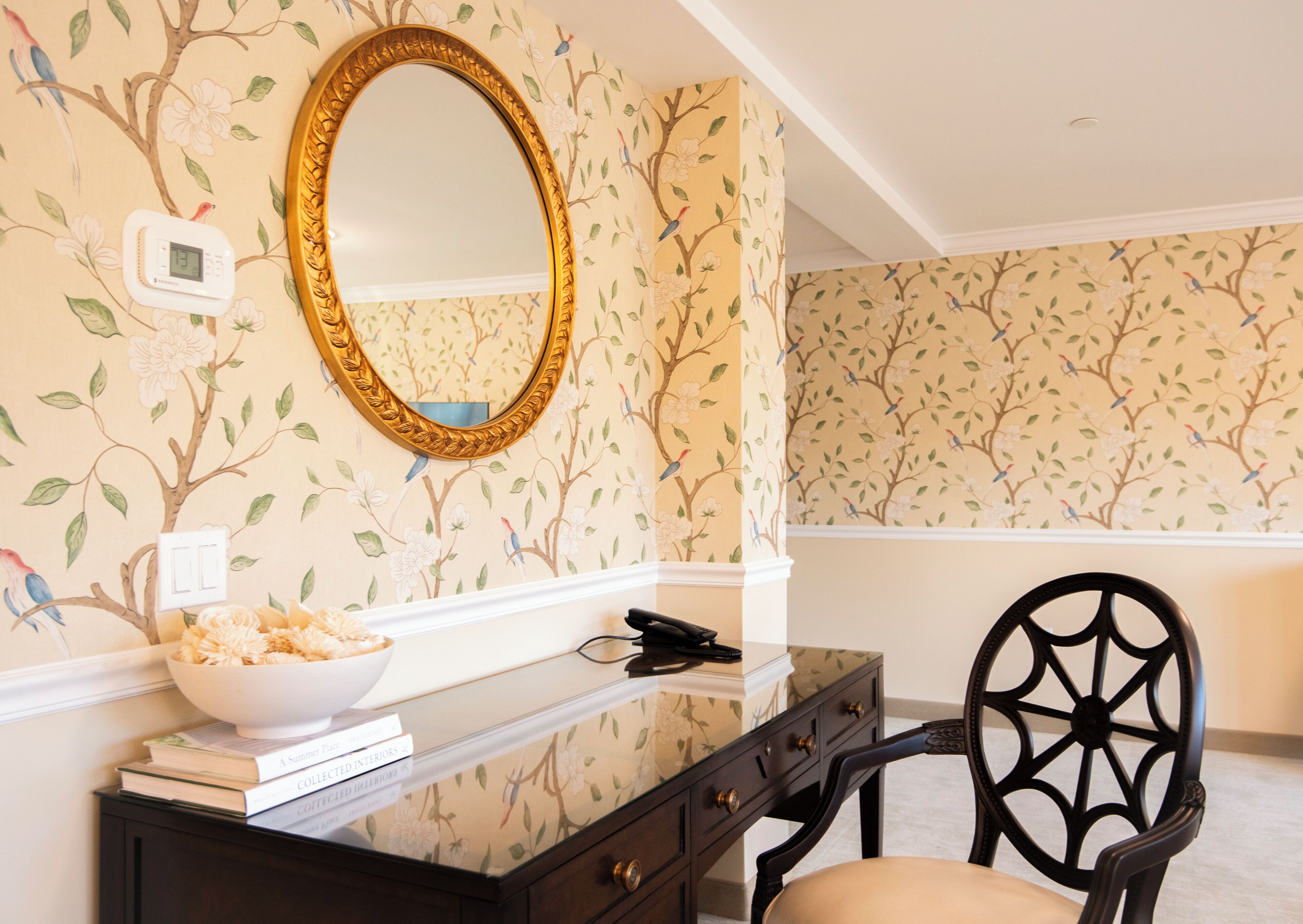 A room with a large mirror, a bowl of snacks, and a chair.