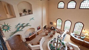 A spacious living area with a fireplace, comfortable seating, and a decorative fountain.