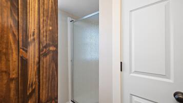 A wooden door with a glass panel and a white door with a handle.