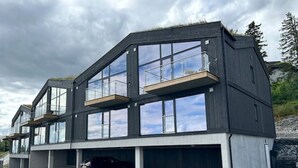 Een modern gebouw met twee verdiepingen, grote ramen en balkons.