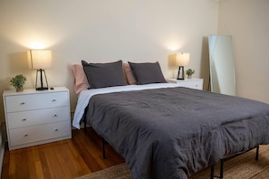 Cozy retreat with a large bed, bedside tables, and a mirror.