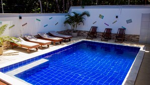 A swimming pool with lounge chairs and a potted plant. - Chalé Recanto dos Passarinhos  (Tibau do Sul)