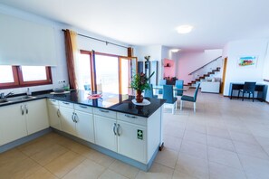A modern kitchen with white cabinets, a black countertop, and a large window.