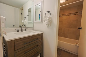 A bathroom with a sink, mirror, towel rack, and a bathtub. - Wild Irishman 2 bed 2 bath Sleeps 9 WIBH (Keystone)