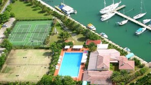 An aerial view of a property with a swimming pool, tennis courts, and a marina with boats. - 4 Guests - Stunning View - Pool - South Finger (Jolly Harbour)