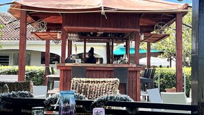 A covered outdoor seating area with a bar, wicker furniture, and a view of a house in the background. - 4 Guests - Stunning View - Pool - South Finger (Jolly Harbour)