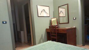 A bedroom with a bed, a desk, and two framed pictures on the wall. - Casa Castelli Holiday Apartment (Bagheria)