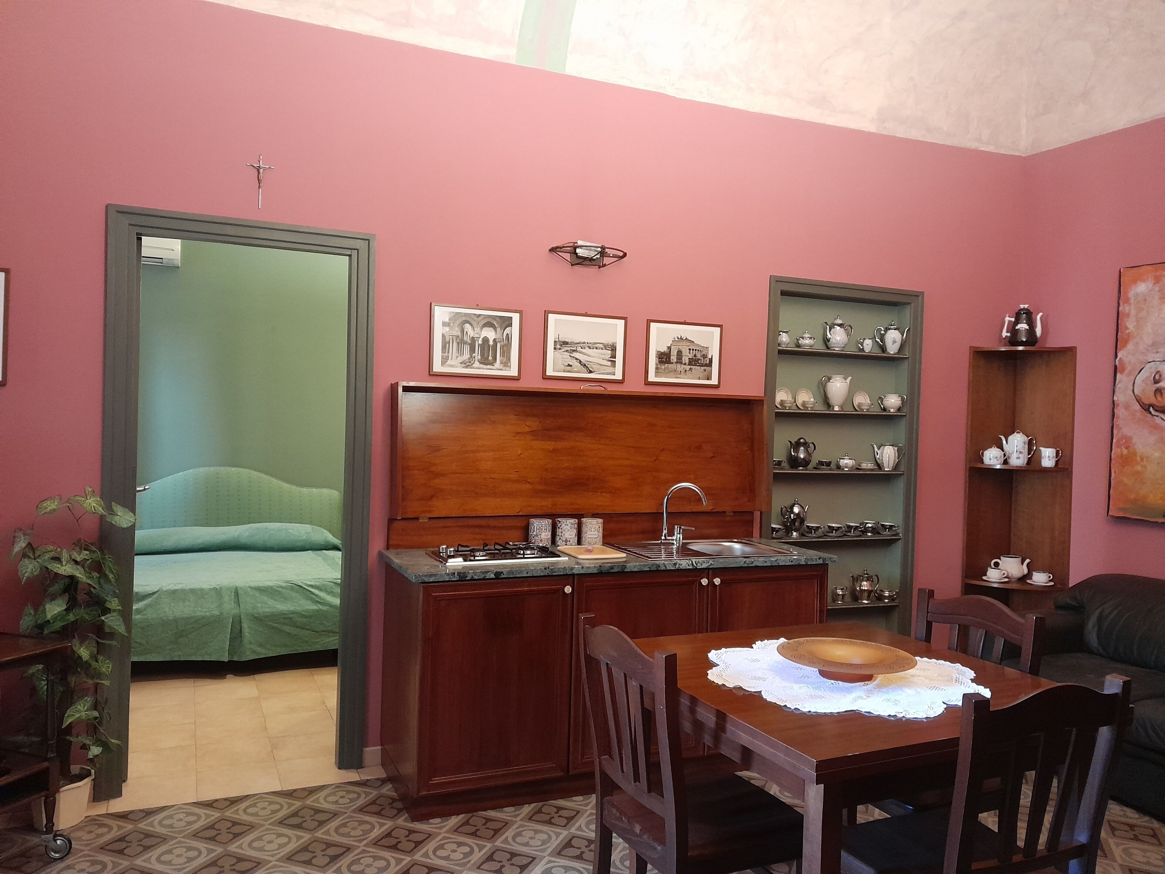 Un ambiente compatto con angolo cottura, zona pranzo e un letto.