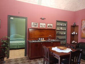 A compact living space with a kitchenette, a dining area, and a bed. - Casa Castelli Holiday Apartment (Bagheria)