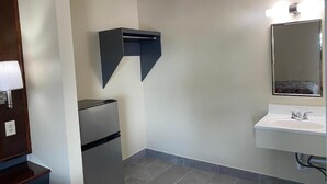 Ein Badezimmer mit Waschbecken, Spiegel und kleinem Kühlschrank.