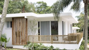 A modern house with a white exterior, large windows, and a wooden fence. - Koserê (Ilhabela)