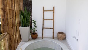 A spa area with a hot tub, bamboo decor, and a ladder. - Koserê (Ilhabela)