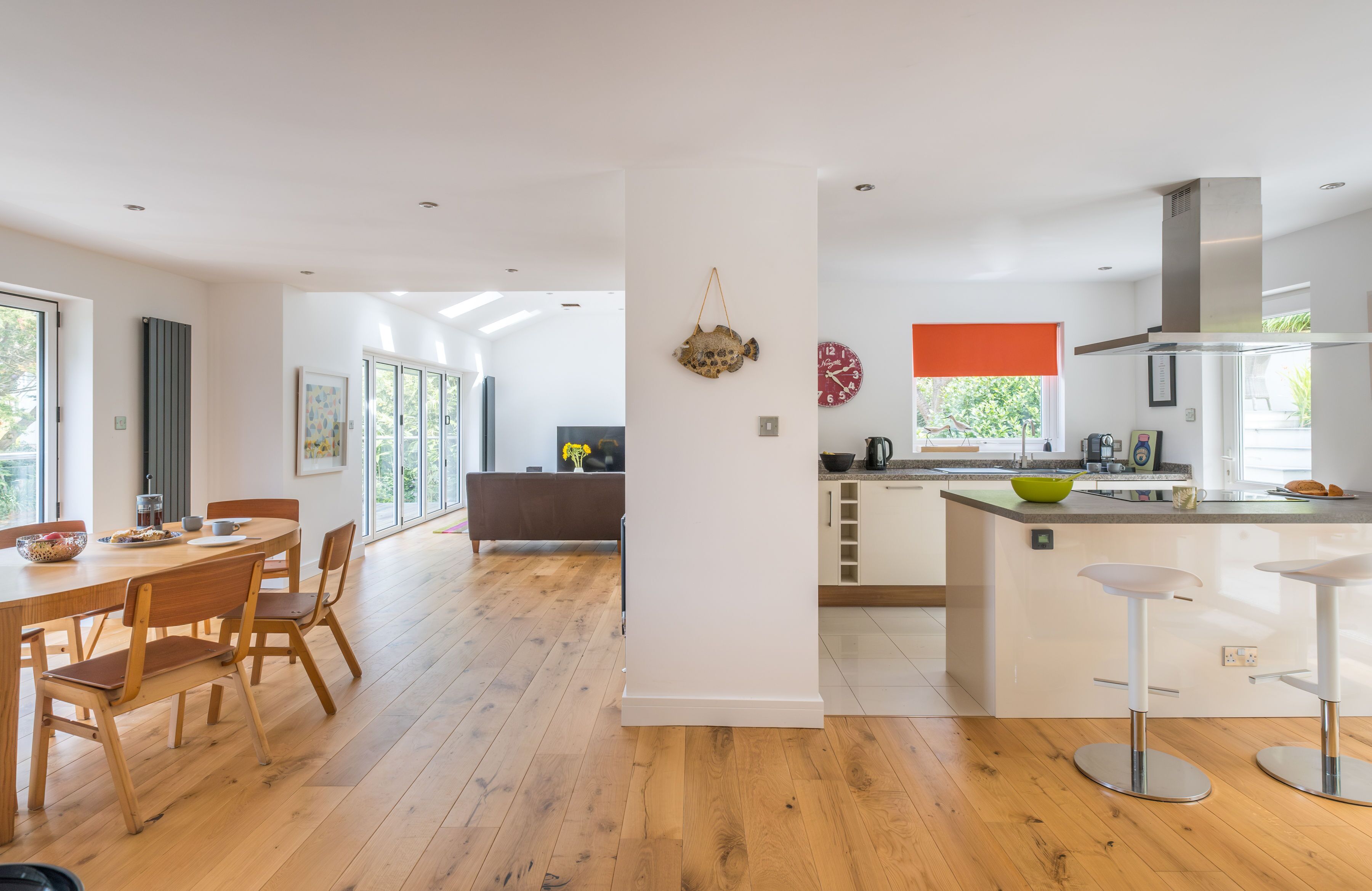 Une cuisine moderne dotée d’un îlot central, d’une table à manger en bois et de chaises.