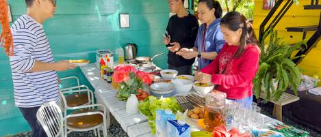 Una mesa de comedor con comida y bebidas, rodeada de sillas.