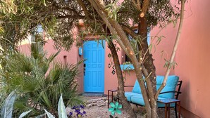 A garden with a blue door, a blue chair, and various plants. - Charming Adobe Casita! Large lot in upscale quiet neighborhood. STR 15734641 (Fountain Hills)