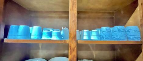 Un espacio de almacenamiento con estanterías que contienen varios utensilios de cocina.