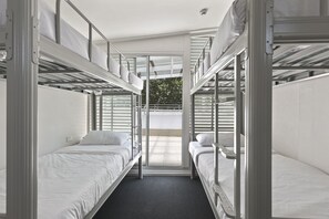 A bunk room with two beds, a window, and a door. - Urban Nomad Potts Point - 18-39 (Potts Point)
