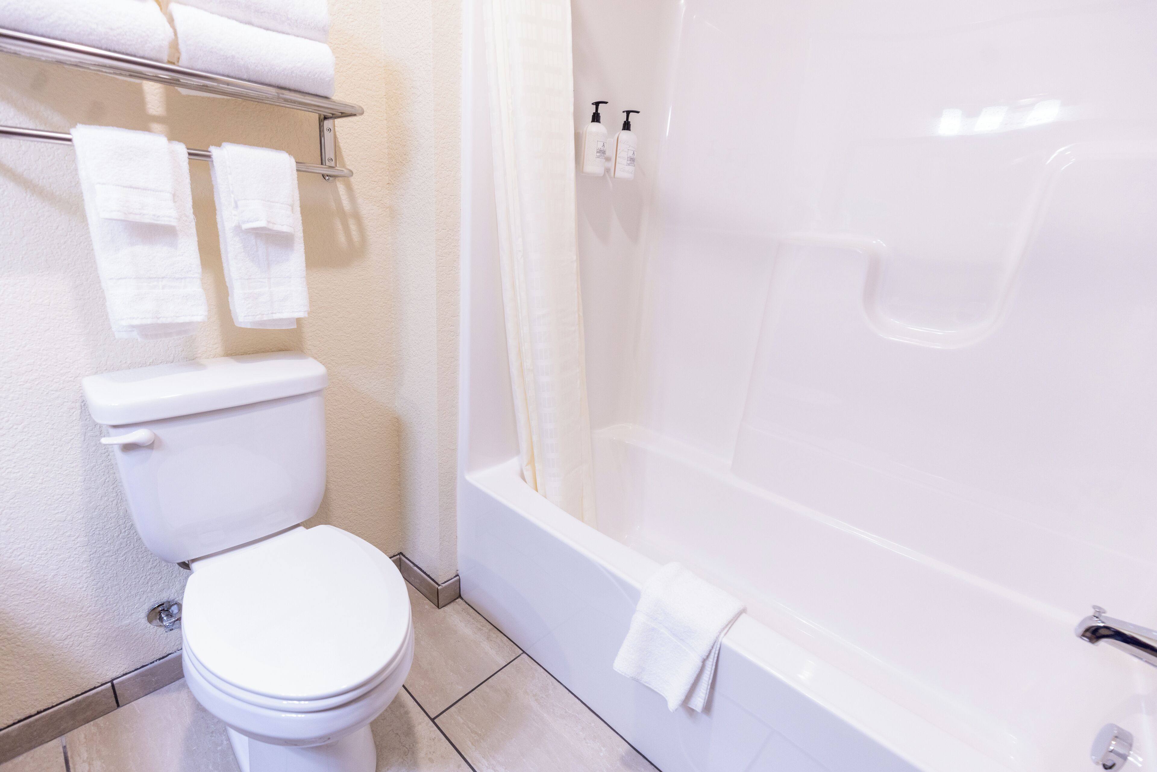 A bathroom with a toilet, a bathtub, and a shower curtain.