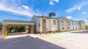 A hotel with a covered entrance, stone pillars, and a sign indicating it is a Courtyard Inn & Suites. - Cobblestone Inn & Suites - Winters (Winters)