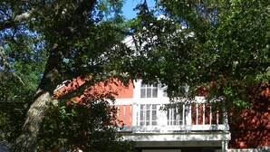 A two-story house with a front porch, a mailbox, and a staircase leading to the entrance. - Nestled in Hill Country- Minutes from multiple attractions (Spring Branch)