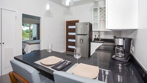 A modern kitchen with a central island, a refrigerator, and a coffee maker. - New modern condo 3 minute walk to West Bay Beach (West Bay)