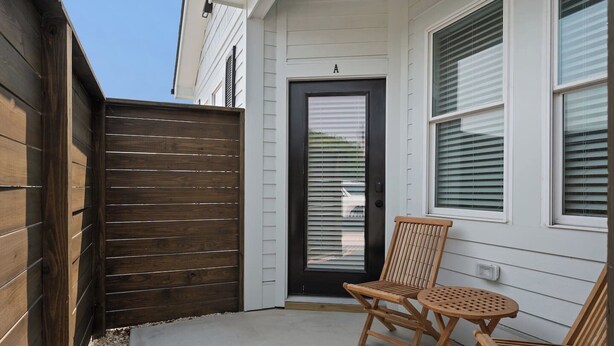 A wooden fence, a black door, and a wooden bench with a table in front of a house. - Barefoot Bliss - Single Level Steps to the Beach (Corolla)