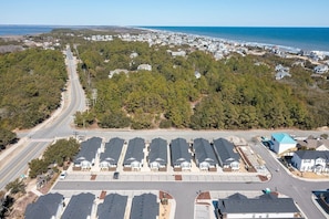 Un quartier résidentiel composé d’une rangée de maisons, d’un parking et d’une route qui serpente à travers le paysage.