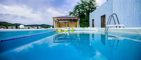 Una piscina al aire libre de temporada, tumbonas
