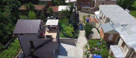 A residential area with multiple houses, a narrow street, and some greenery.