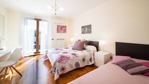 Une chambre à coucher comprenant un lit, des tables de chevet, un bureau et une chaise.