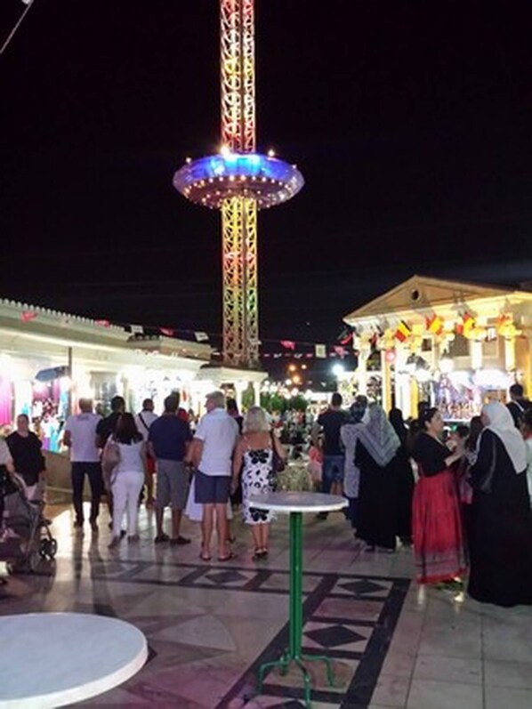A public square with a tall, brightly lit tower and a small table in the foreground. - Luxury Studio Apartment - Sea View In Sousse (Port El Kantaoui)