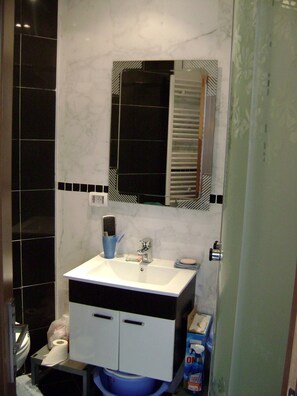 A bathroom with a white sink, a mirror, and a toilet. - Luxury Studio Apartment - Sea View In Sousse (Port El Kantaoui)