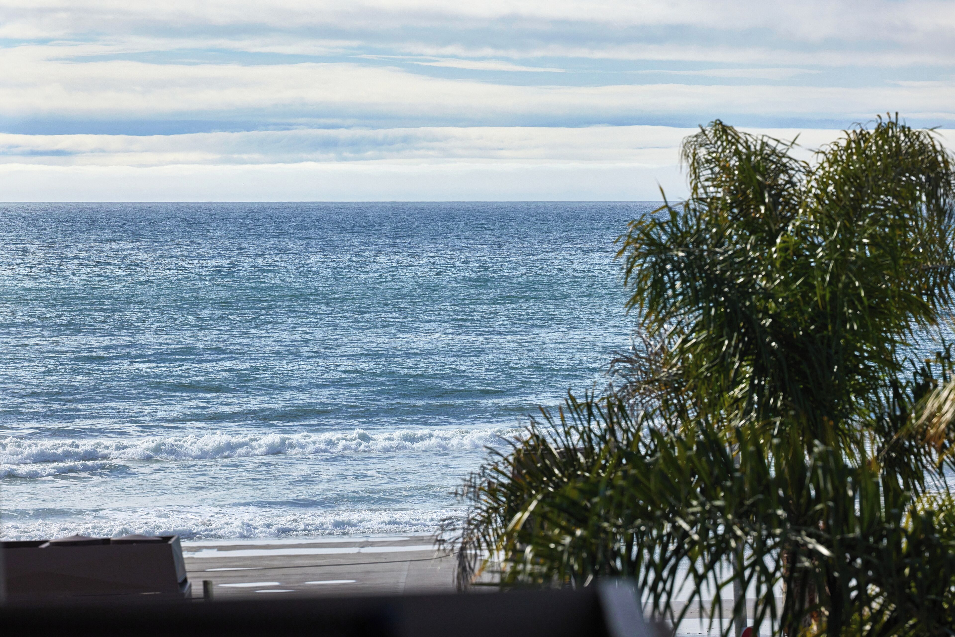 Une vue sur l’océan, avec des vagues et un ciel dégagé.